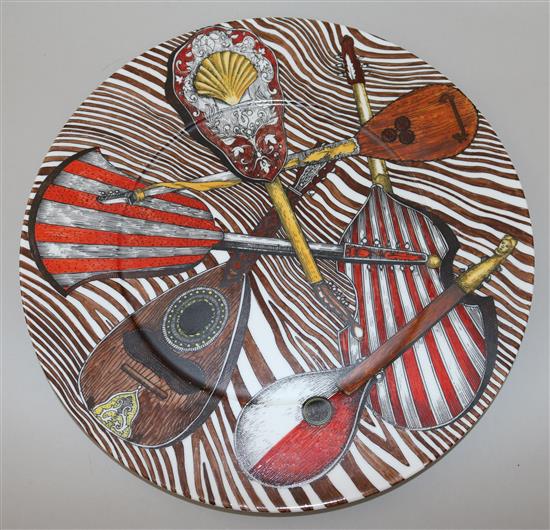 A large Fornasetti Strumenti Musicali pattern dish and four similar plates, 20.5.cm - 32cm